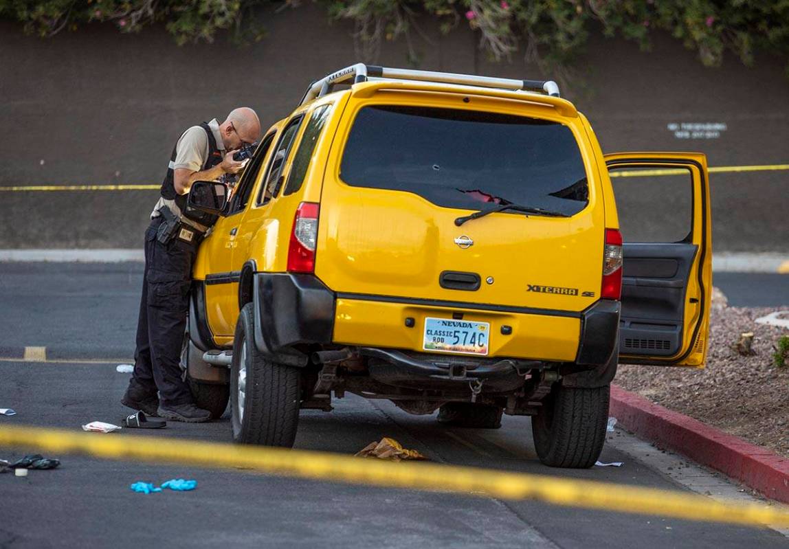 Metro Senior Crime Scene Analyst Joseph Szukiewicz works the scene of a homicide at the Solaire ...