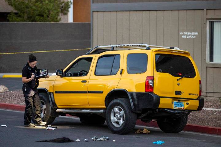 A Metro crime scene analyst works the scene of a homicide at the Solaire East Apartments on Sat ...