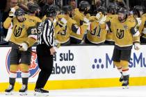 Golden Knights defenseman Shea Theodore (27) and right wing Mark Stone (61) are congratulated b ...