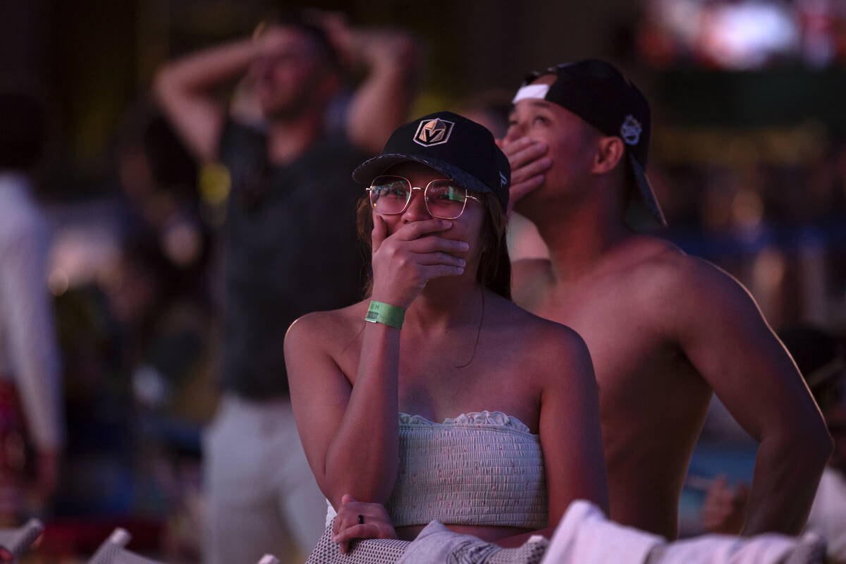 Golden Knights fans Aimee Encamacion, center, and her husband Allan Obando, right, react as the ...