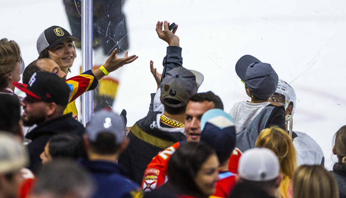 A fan grabs a puck tossed to him by Golden Knights right wing Keegan Kolesar (55) during warm u ...