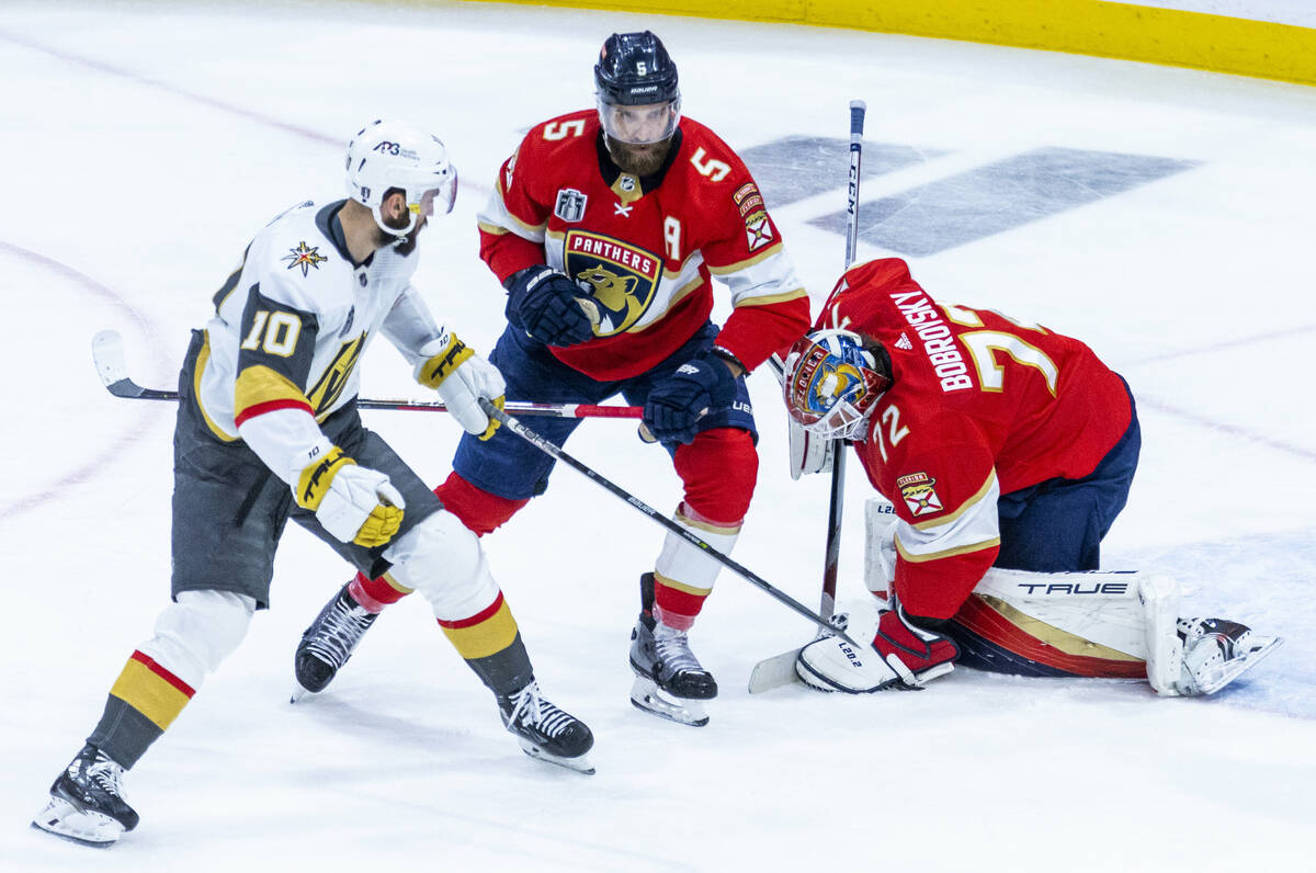 Florida Panthers goaltender Sergei Bobrovsky (72) smothers a shot with defenseman Aaron Ekblad ...