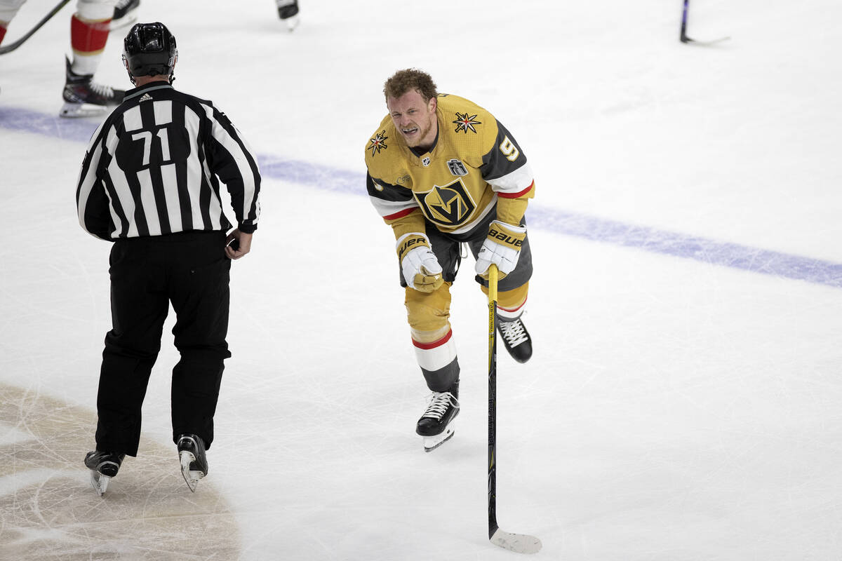 Golden Knights center Jack Eichel (9) skates off the ice from a scrum while grimacing during th ...