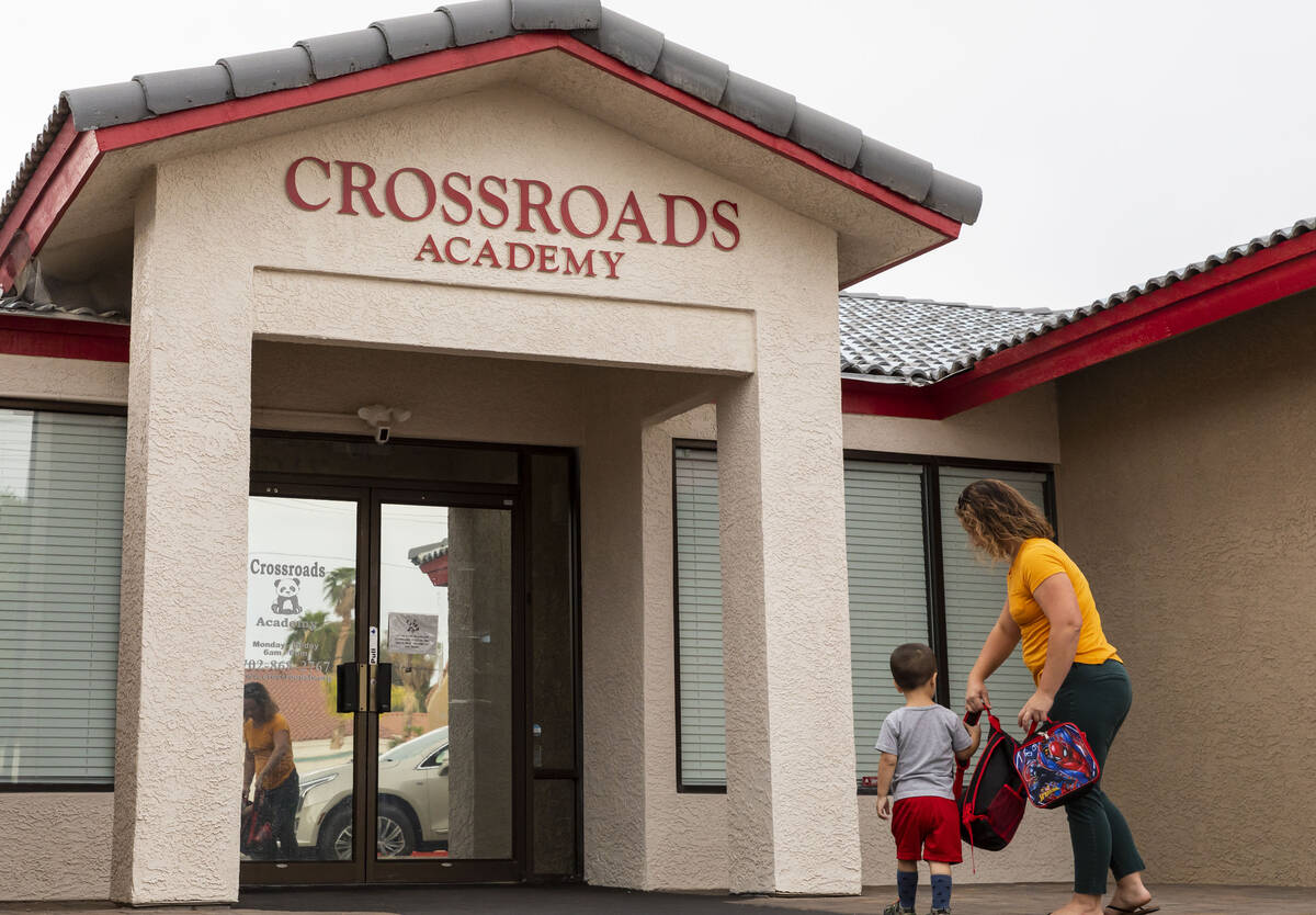 A mother walks her son into the Crossroads Academy preschool on Wednesday, June 7, 2023, in Las ...