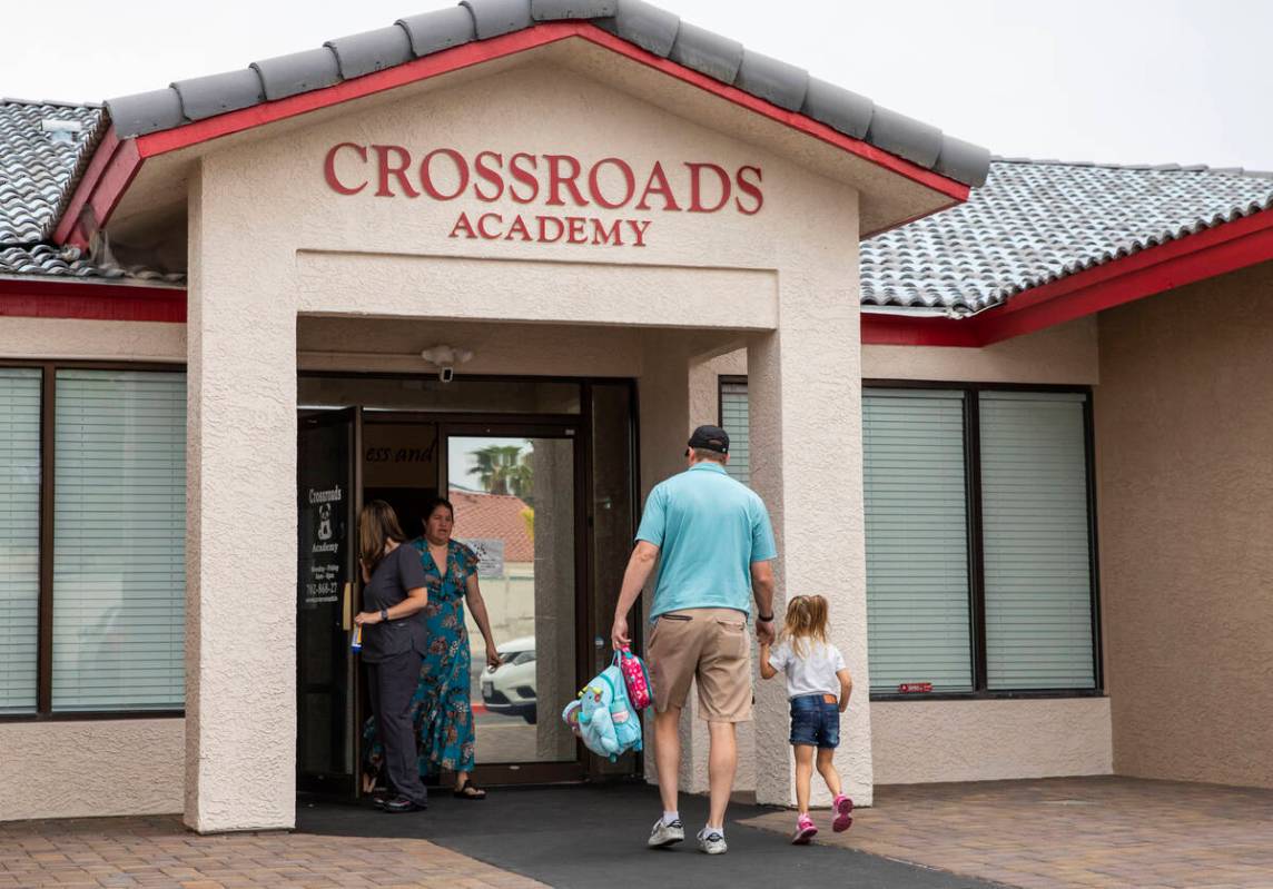 Children are dropped off by their families at the Crossroads Academy preschool on Wednesday, Ju ...