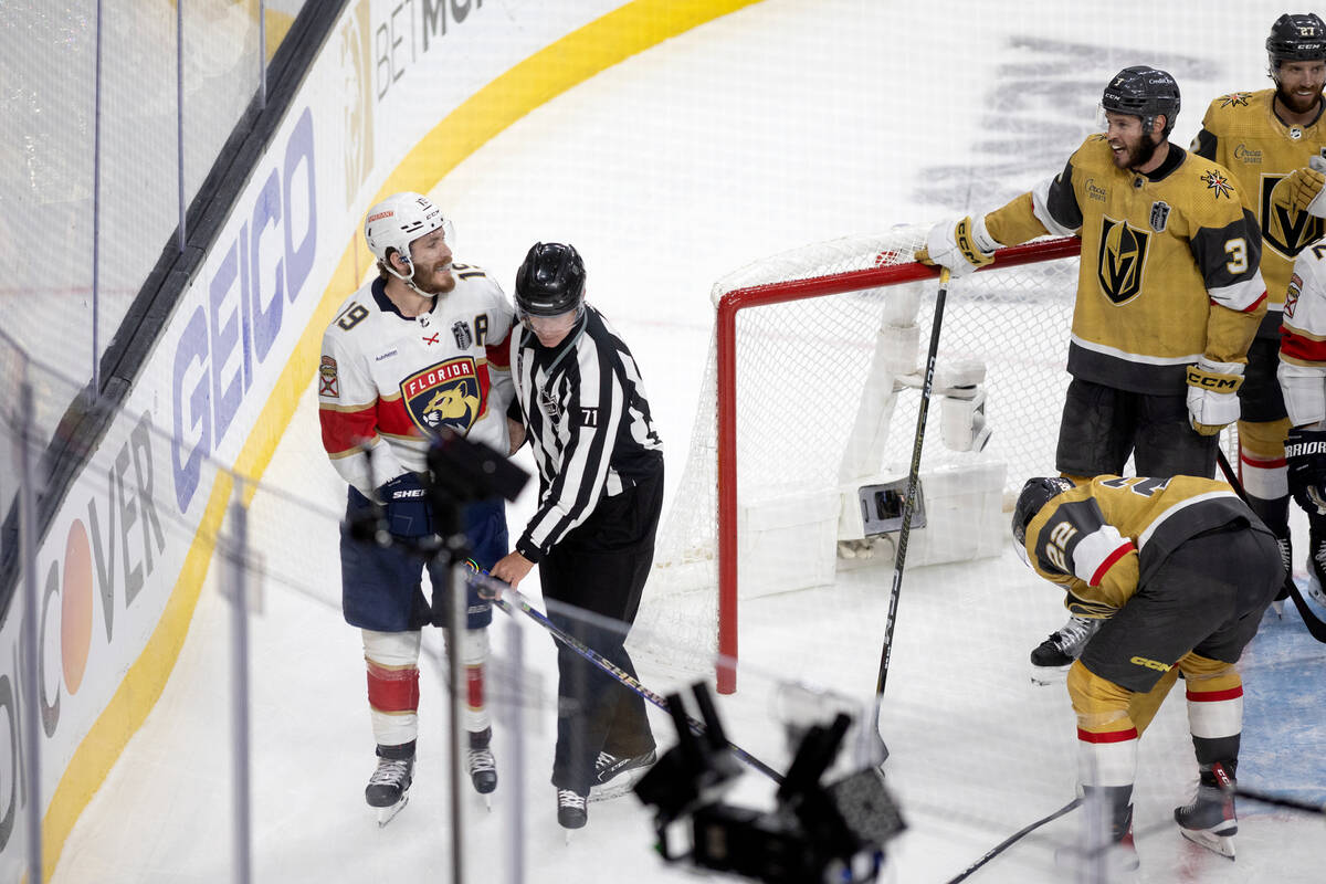 Referee Brad Kovachik (71) escorts Florida Panthers left wing Matthew Tkachuk (19) from a scrum ...