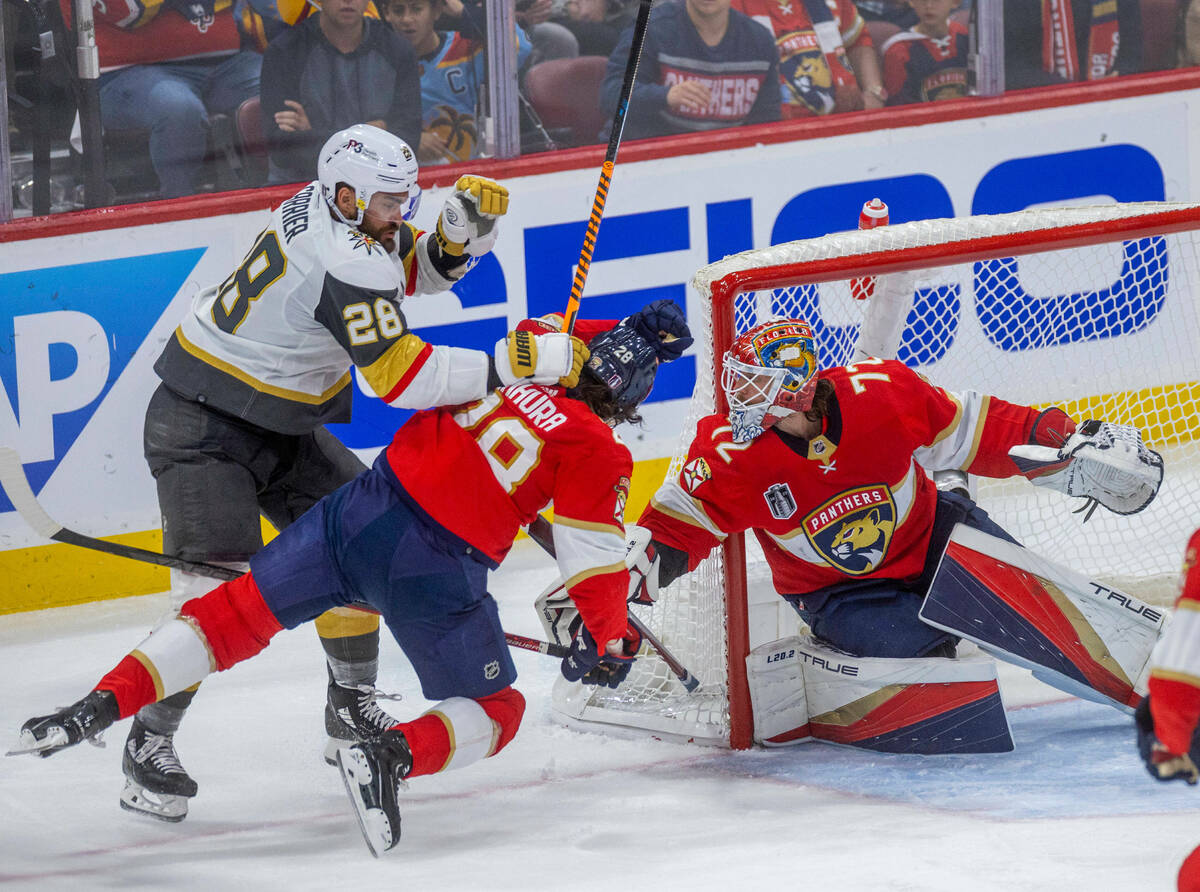 Golden Knights left wing William Carrier (28) checks Florida Panthers defenseman Josh Mahura (2 ...