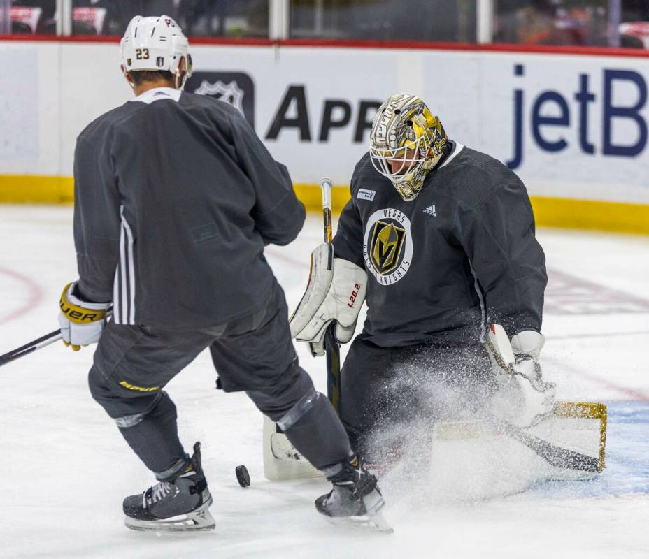 Golden Knights defenseman Alec Martinez (23) kicks up some ice while chasing a puck to goaltend ...