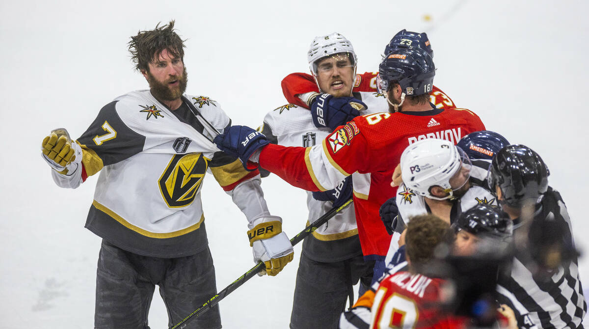 Golden Knights defenseman Alex Pietrangelo (7) and defenseman Zach Whitecloud (2) are grabbed b ...