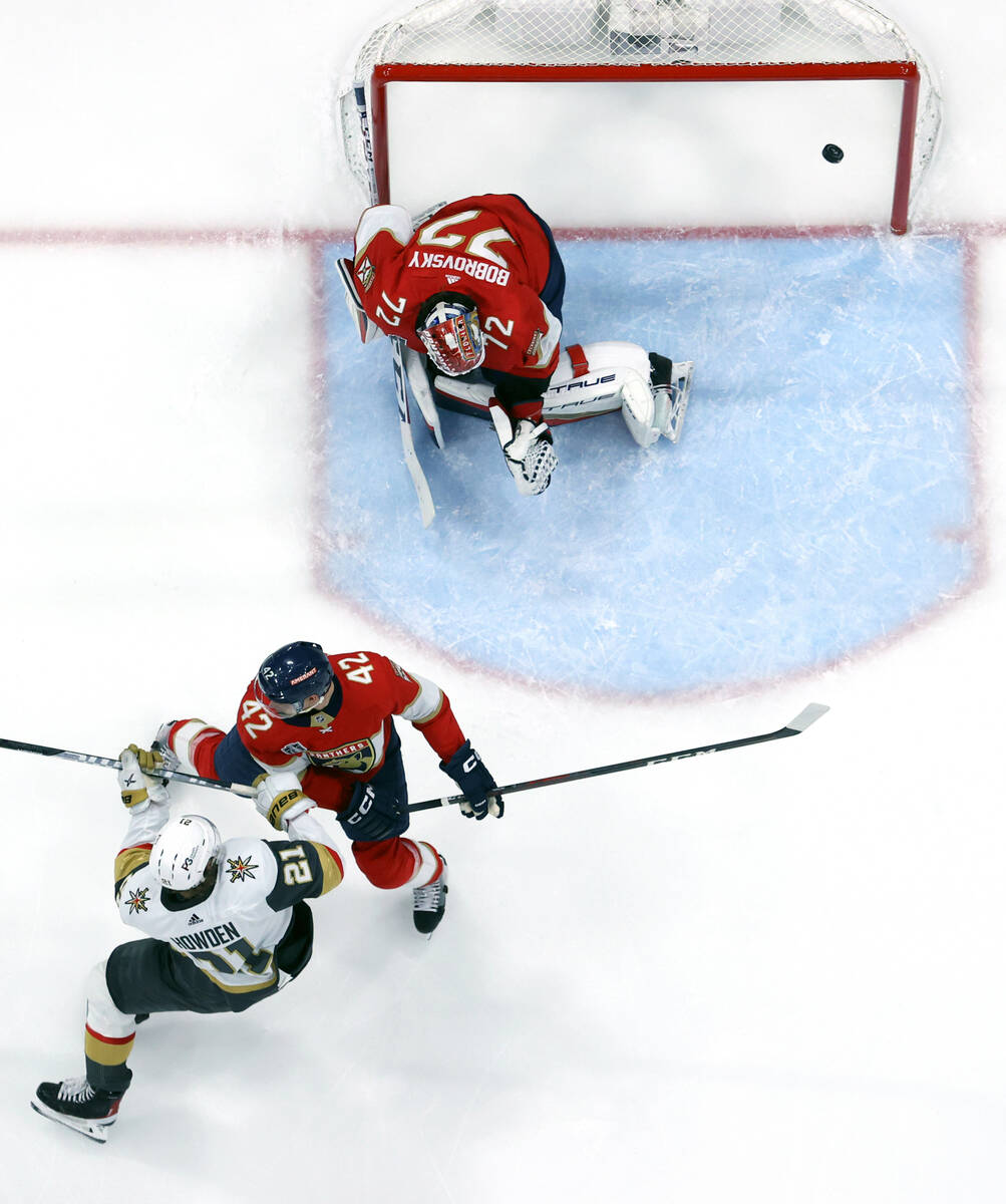 Golden Knights center Brett Howden (21) gets off a shot past Florida Panthers defenseman Gustav ...