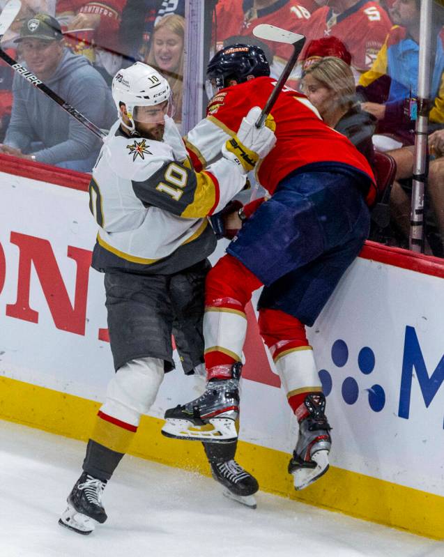 Golden Knights center Nicolas Roy (10) checks Florida Panthers defenseman Aaron Ekblad (5) into ...