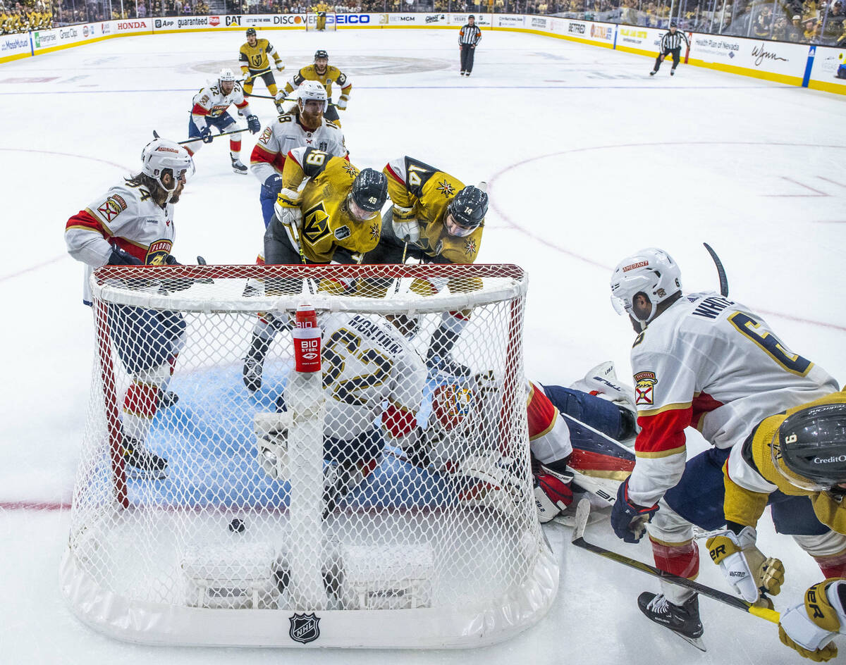 Golden Knights center Ivan Barbashev (49) and defenseman Nicolas Hague (14) get the puck past ...