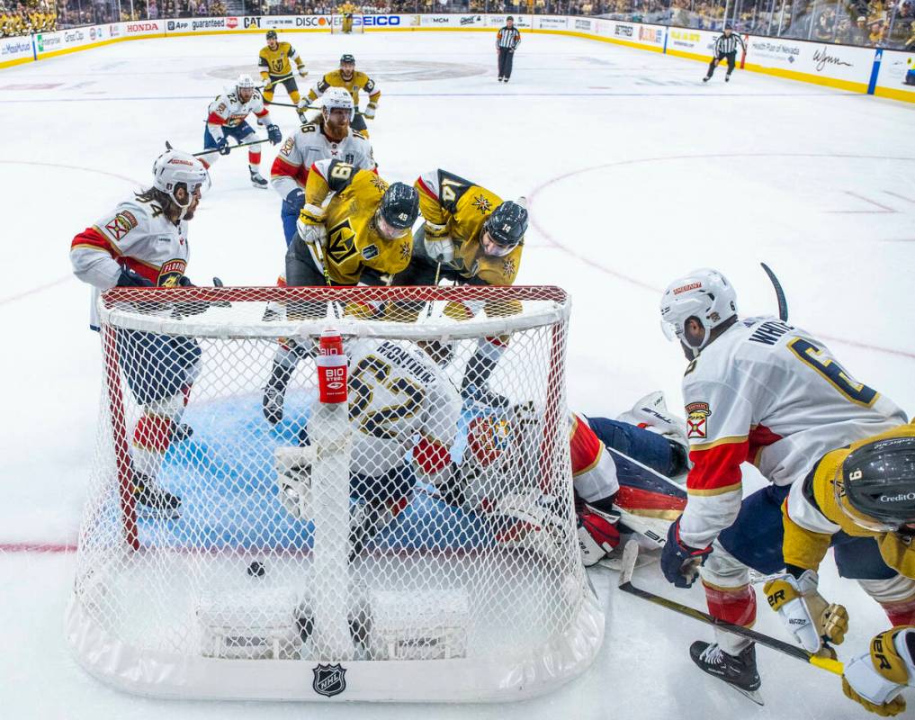 Golden Knights center Ivan Barbashev (49) and defenseman Nicolas Hague (14) get the puck past ...