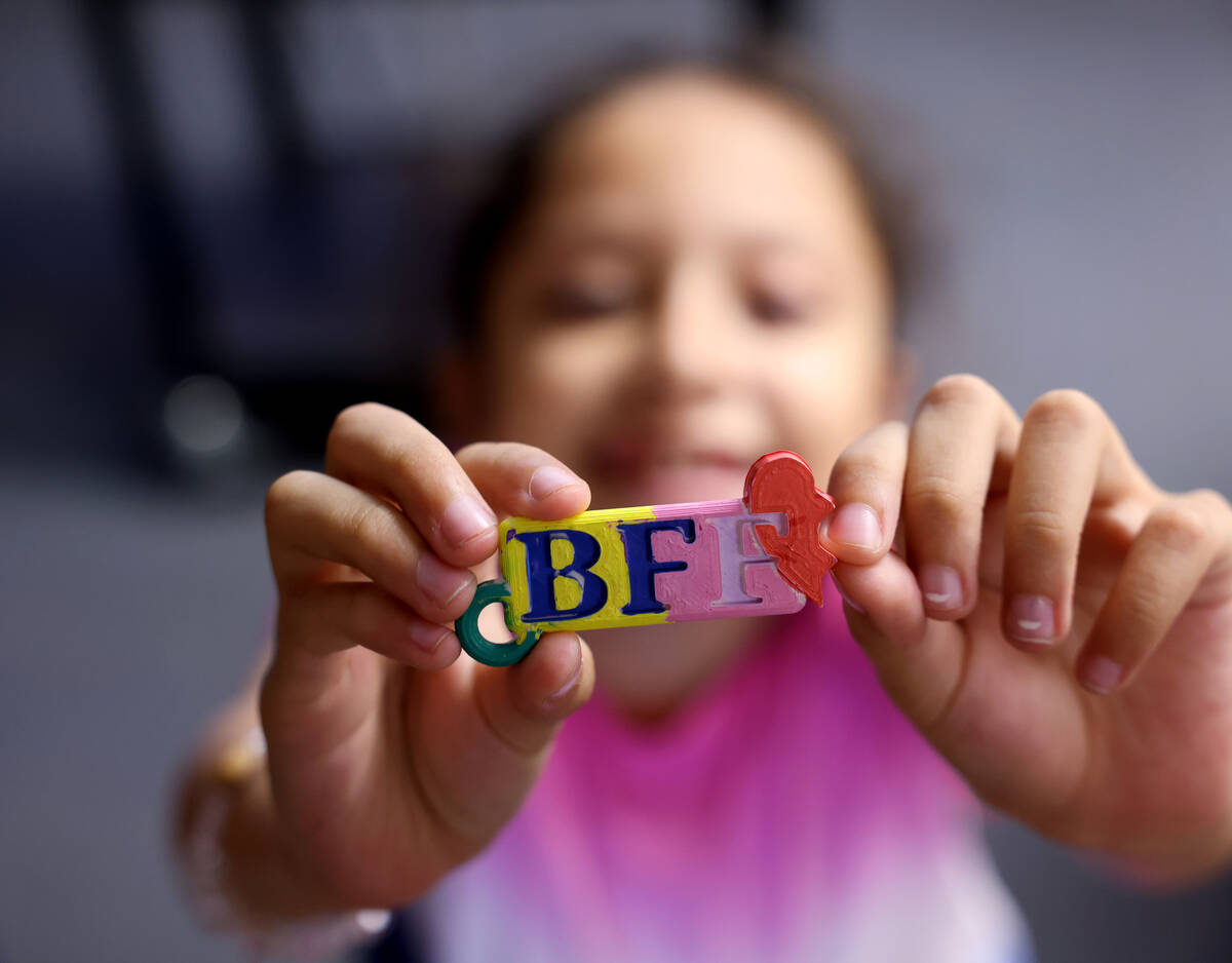 Patricia Hernandez, 9, shows a keychain she made on a 3D printer during the voluntary summer ac ...