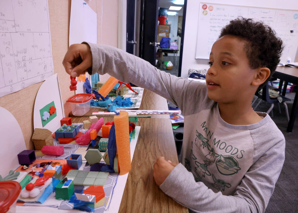 Michael Naqvi, 9, shows a house he designed during the voluntary summer acceleration program at ...