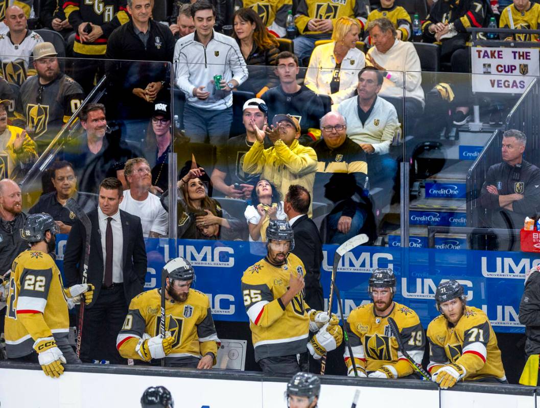 Golden Knights head coach Bruce Cassidy tosses a puck over the glass to a lucky fan during peri ...