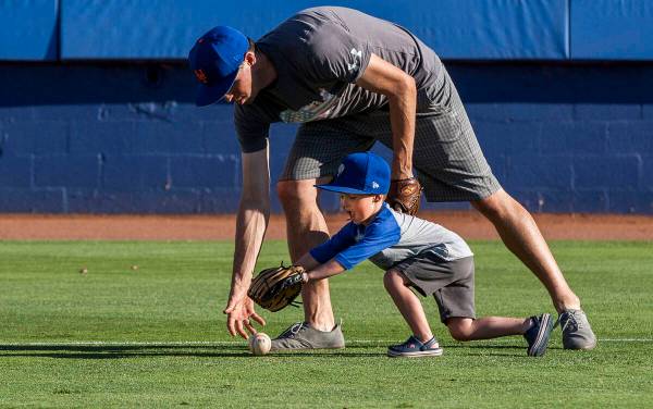 Dillon Truman, 4, races for the ball with his father Jared during father and child catch, an an ...