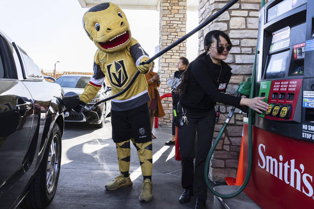 May Woody, right, assistant manager at Smith's, helps Golden Knights mascot Chance pumps free g ...