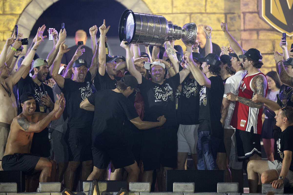 The Golden Knights rally around right wing Phil Kessel, holding the Stanley Cup, as they celebr ...