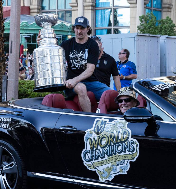 Golden Knights right wing Mark Stone holds the Stanley Cup as team owner Bill Foley, seated, lo ...