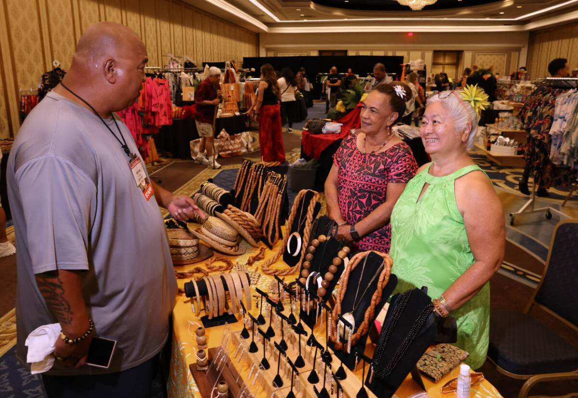 Wayne Kaiwi of Honolulu shops for Hawaiian cultural accessories with Leilani Vierra, right, and ...