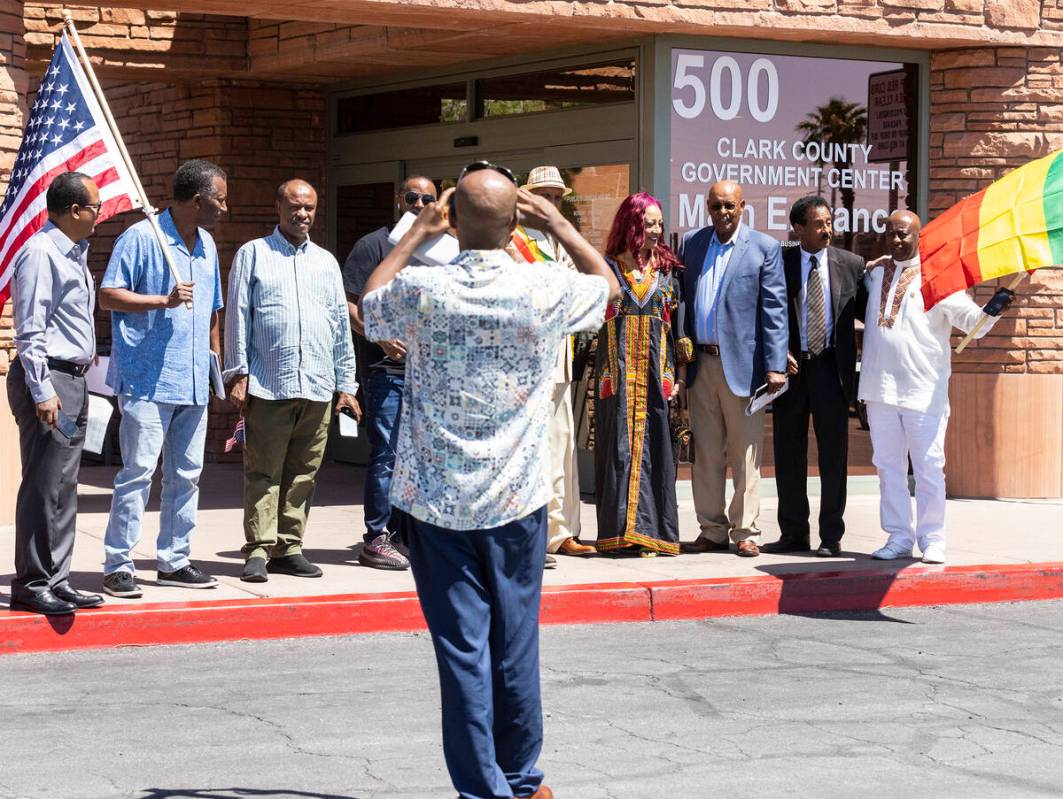 Members of the Ethiopians community wave Ethiopian and American flags as they pose for a photo ...