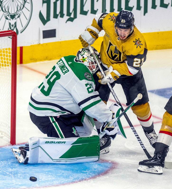 Golden Knights center Brett Howden (21) looks to a puck shot around Dallas Stars goaltender Jak ...