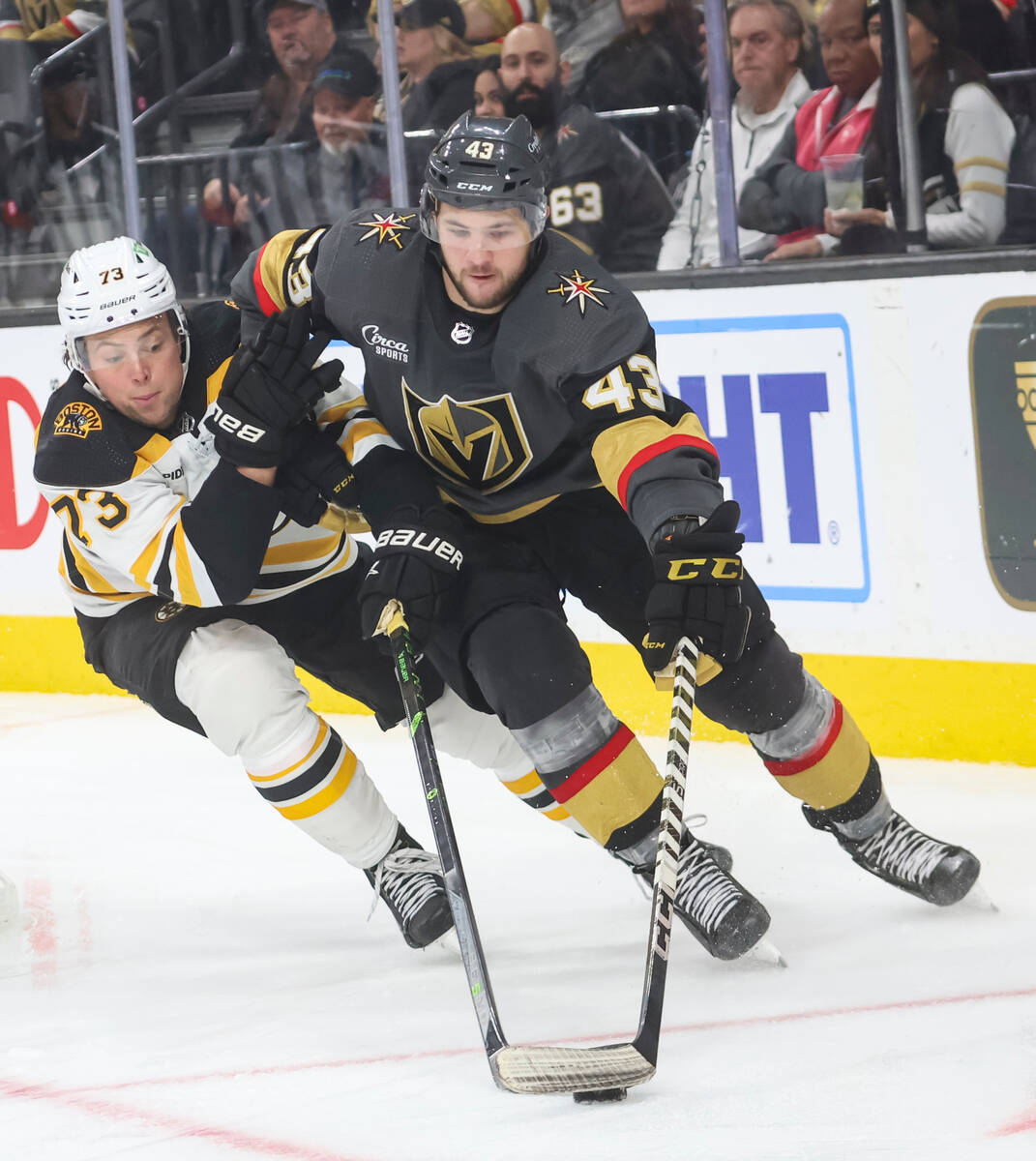 Golden Knights center Paul Cotter (43) guides the puck under pressure from Boston Bruins defens ...