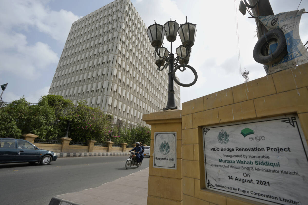 A motorcyclist rides past a head office building of Dawood Hercules Corp, a firm of Pakistan's ...