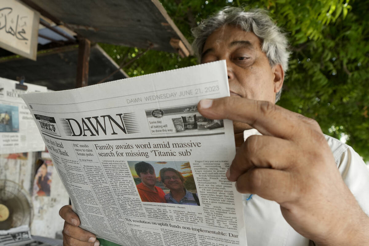 A man reads a copy of a morning newspaper which reports missing Titanic submersible and onboard ...