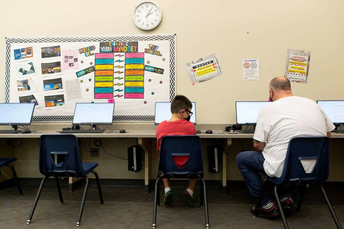 James Ahern, 7, and his father James Ahern Sr. work at Nevada Learning Academy in August 2021 i ...