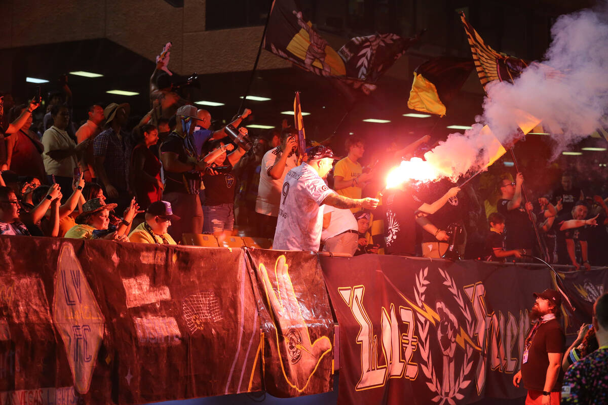 A fan holds a flare during the second half of an USL Championship soccer game between the Las V ...