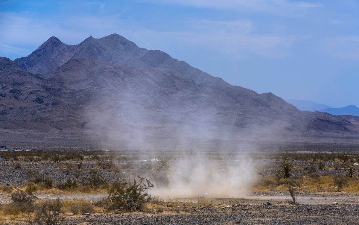 A dust devil spins across the desert within the Nellis Dunes as hot weather moving into the val ...