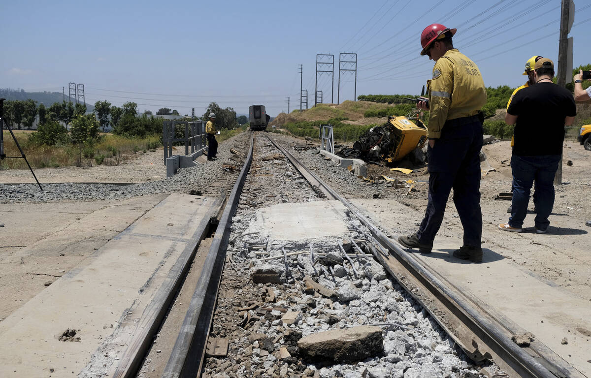 A firefighter examines part of a train track after an Amtrak train derailed in Moorpark, Calif. ...