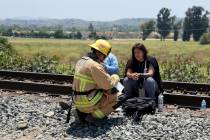 An Oxnard Fire Department firefighter checks out passengers after their Amtrak train derailed i ...