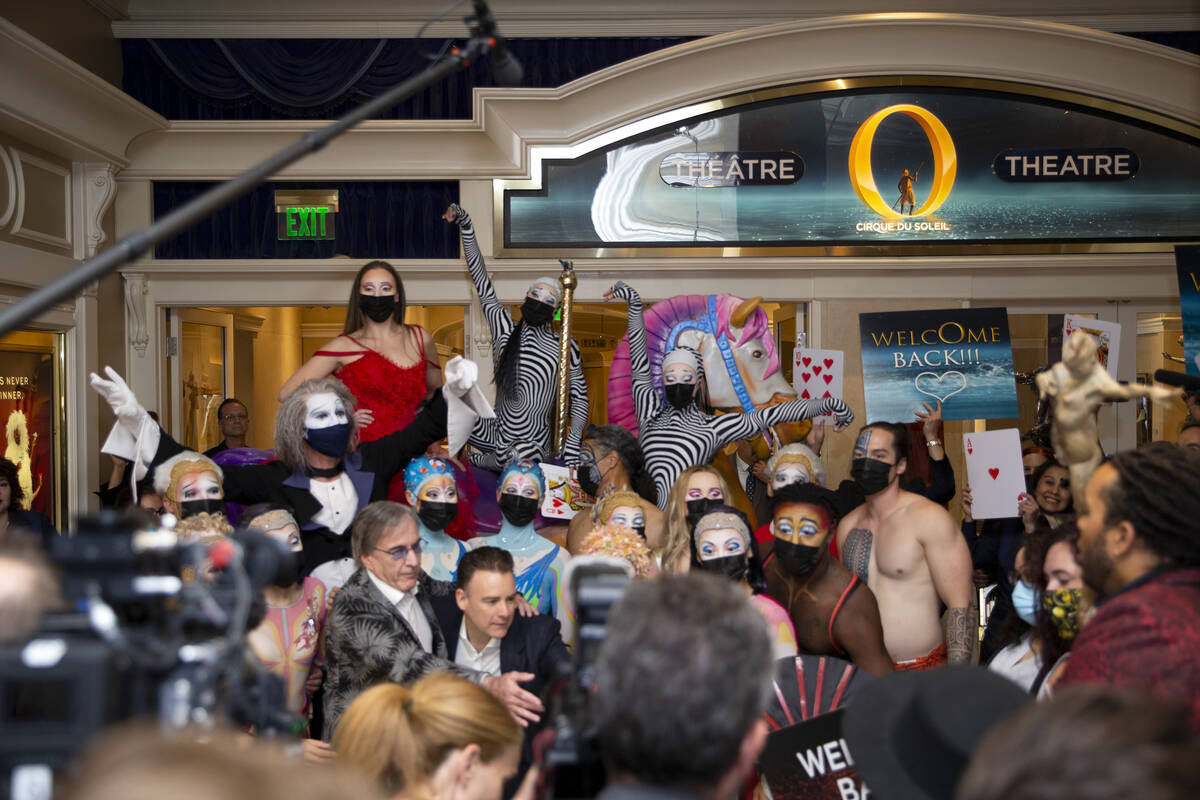 Cast members of "O" pose for photos at the entrance of the show's theater at Bellagio in July 2 ...