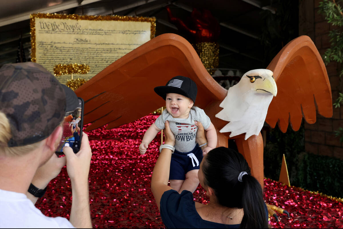 Kit Carson takes a photo of his son Atticus, 6 months, and his wife Leanna Carson with floats u ...