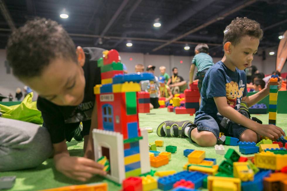 Deon Shepherd, 5, left, and his twin brother Ason Shepherd, 5, play in a LEGO pit during Brick ...