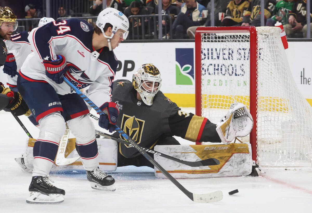 Golden Knights goaltender Jiri Patera (30) defends the net as Columbus Blue Jackets center Cole ...