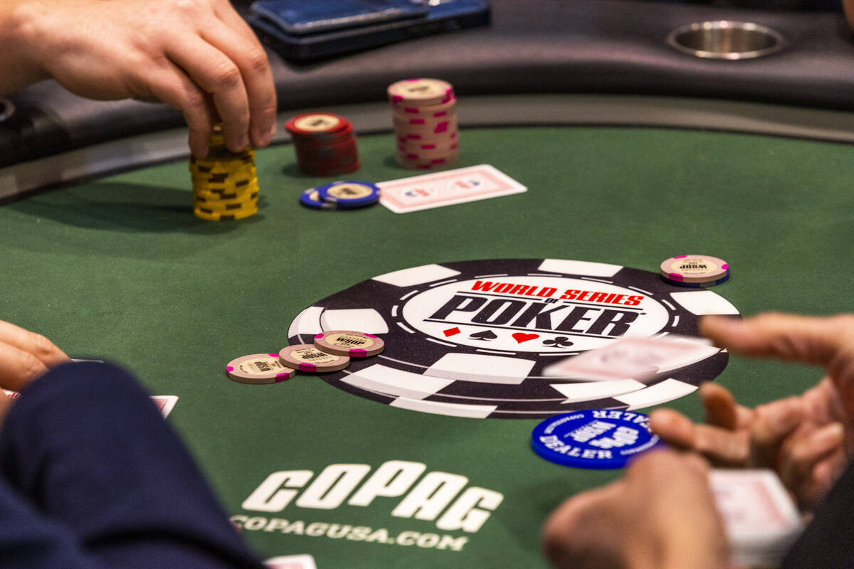 A dealer throws out a second card to poker player Shaun Deeb at his table during the WSOP in th ...