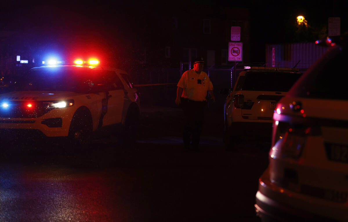 A Philadelphia police officer stands guard at the intersection of 56th Street and Kingsessing A ...