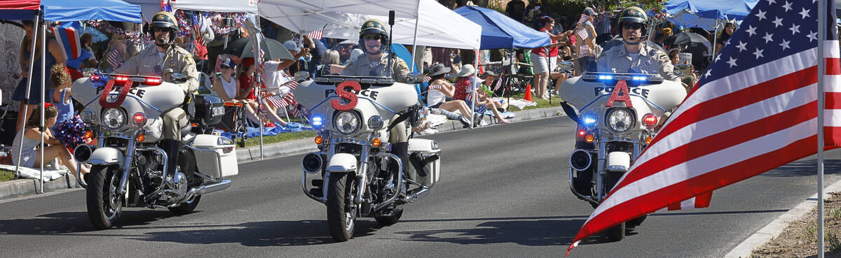 Police officers ride bikes during the annual Summerlin Council Patriotic Parade, Tuesday, July ...