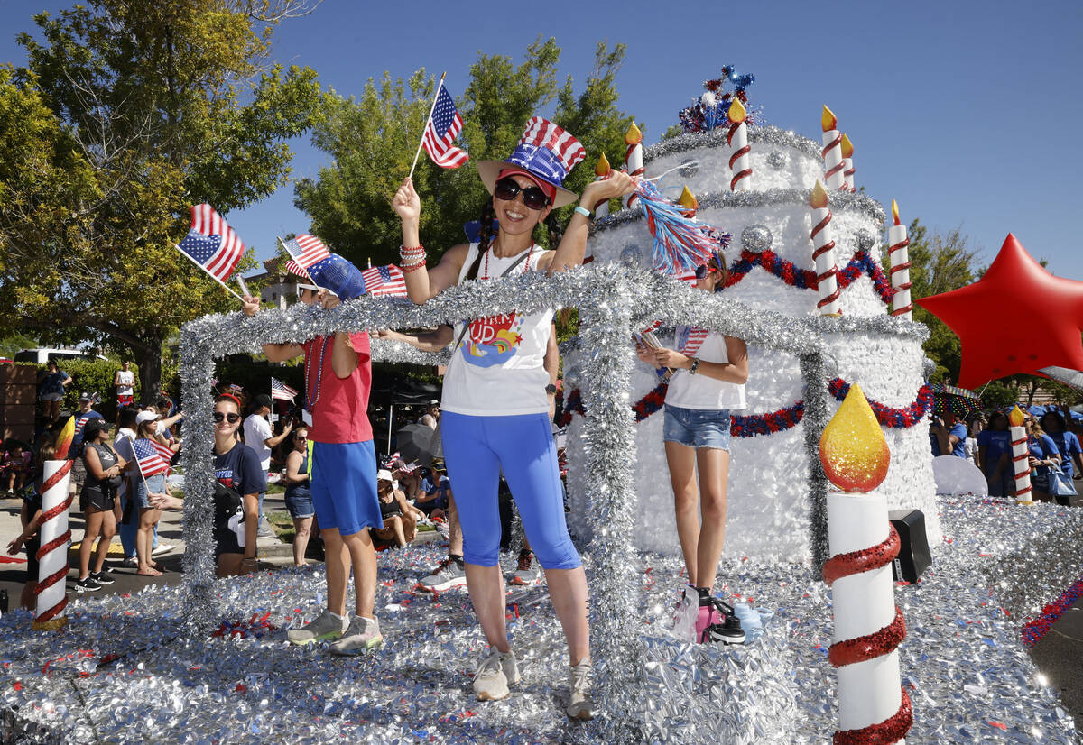 People wave American flags on a float during the annual Summerlin Council Patriotic Parade, Tue ...