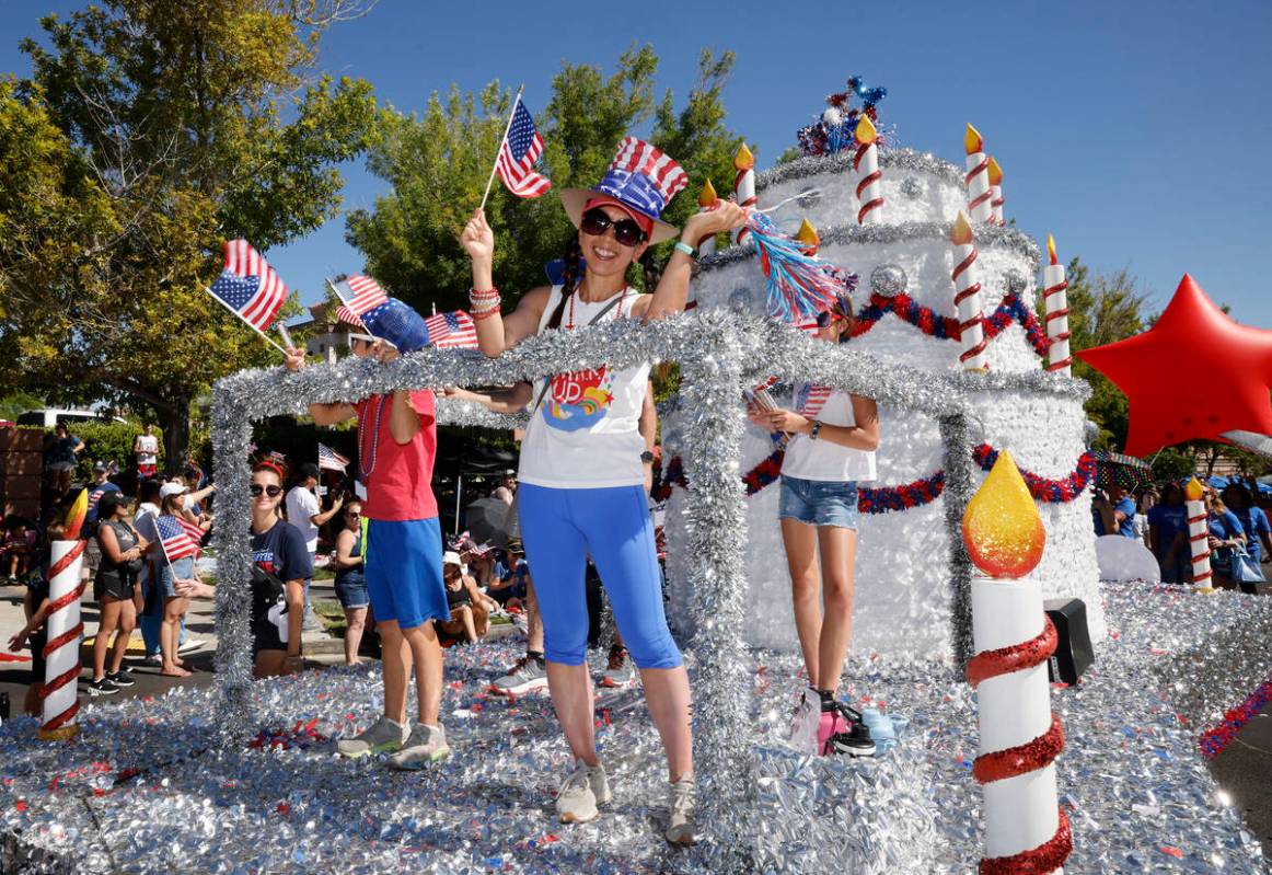 People wave American flags on a float during the annual Summerlin Council Patriotic Parade, Tue ...