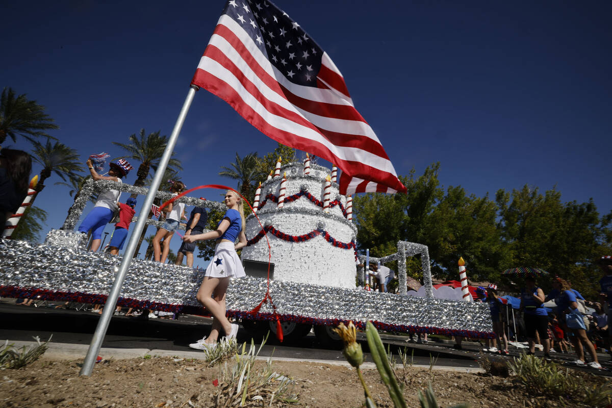 A float passes an American flag during the annual Summerlin Council Patriotic Parade, Tuesday, ...