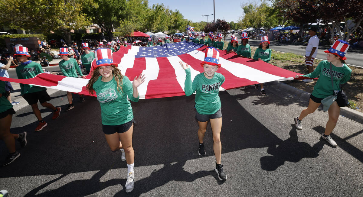 Children carry a large American flag during the annual Summerlin Council Patriotic Parade, Tues ...