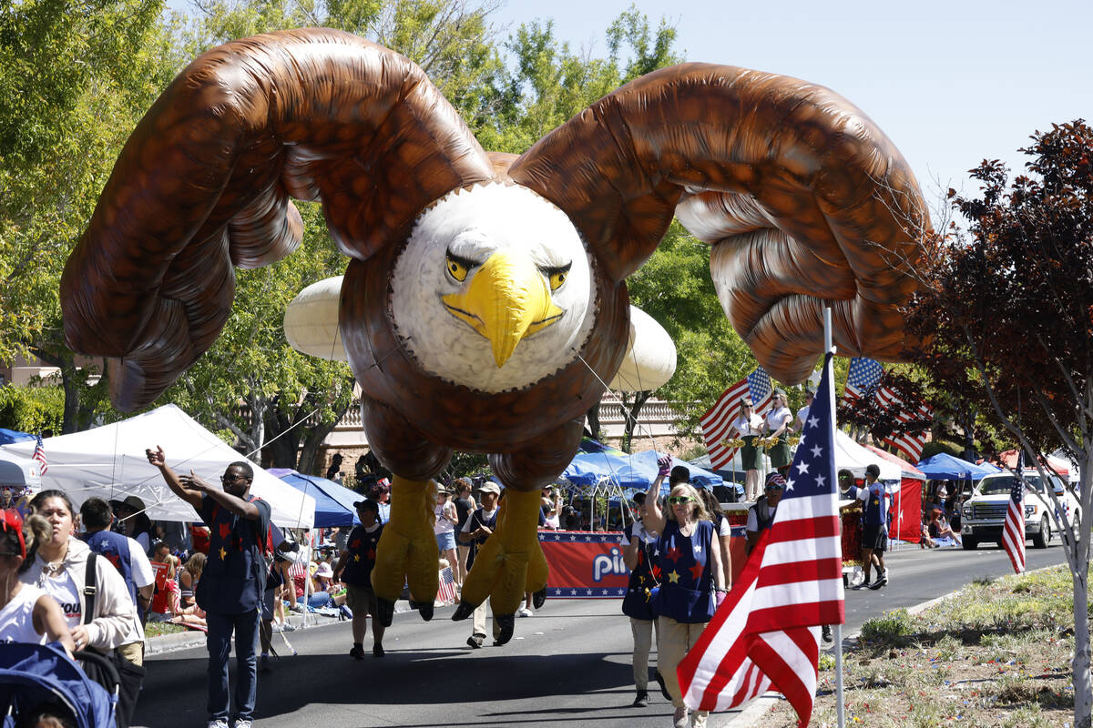 People carry a large American eagle inflatable balloon during the annual Summerlin Council Patr ...