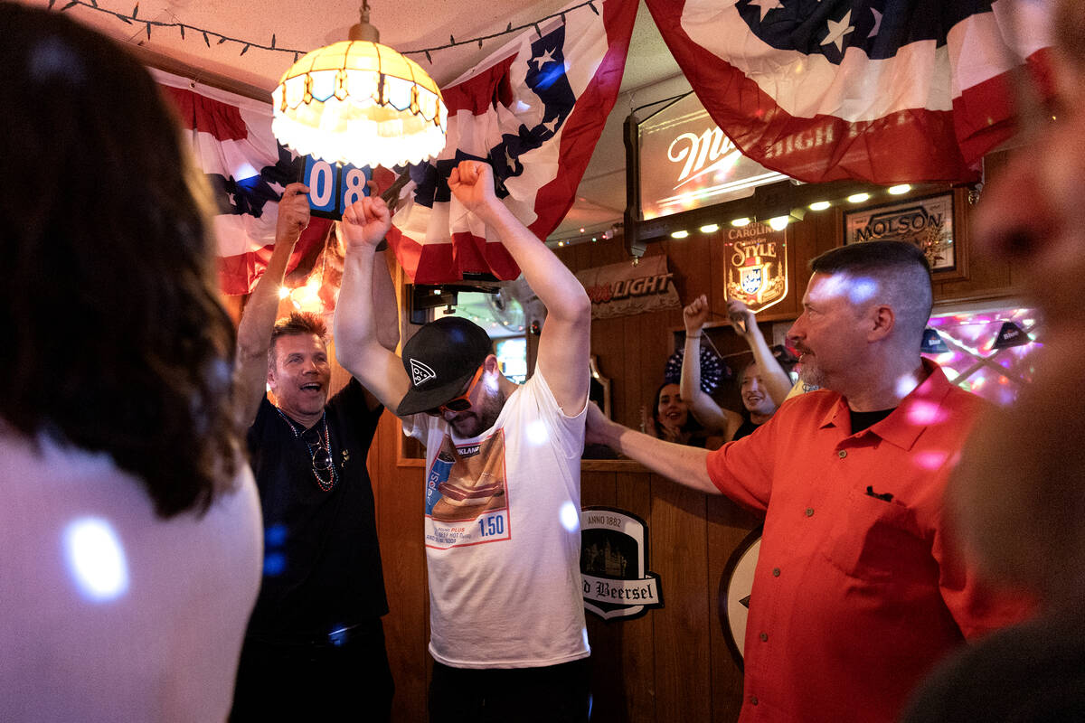 Cameron White cheers as he ties for first place after eating eight hot dogs in five minutes dur ...