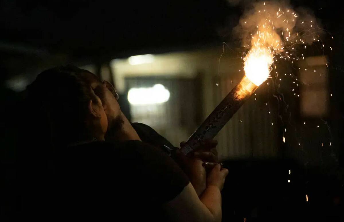 A couple shares a kiss as they light an illegal firework to celebrate Independence Day in July ...