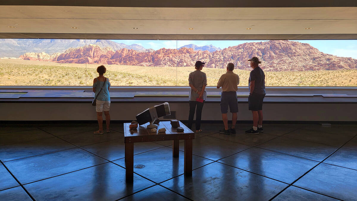 From the air-conditioned comfort of the visitor center, four people enjoy a spectacular panoram ...